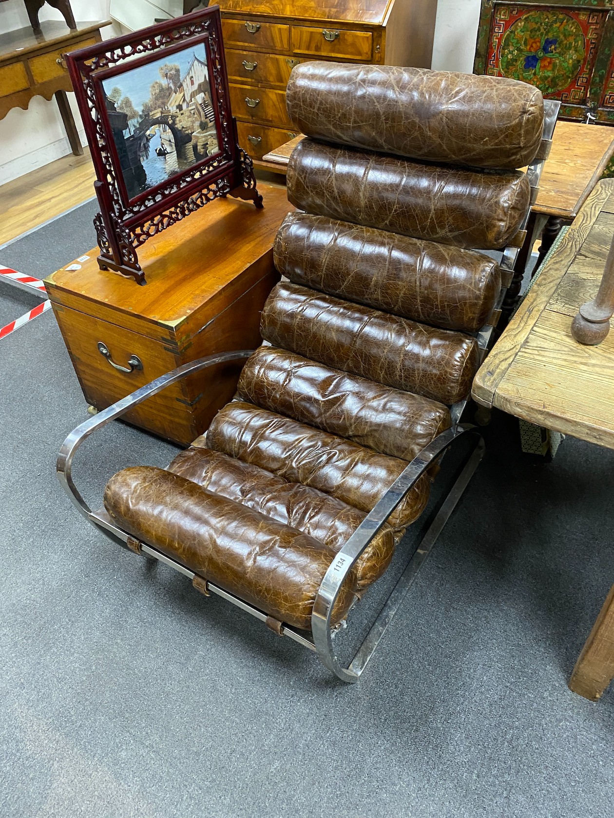 A contemporary polished stainless steel chair, with a brown leather seat and back cushion, width 66cm, depth 90cm, height 105cm